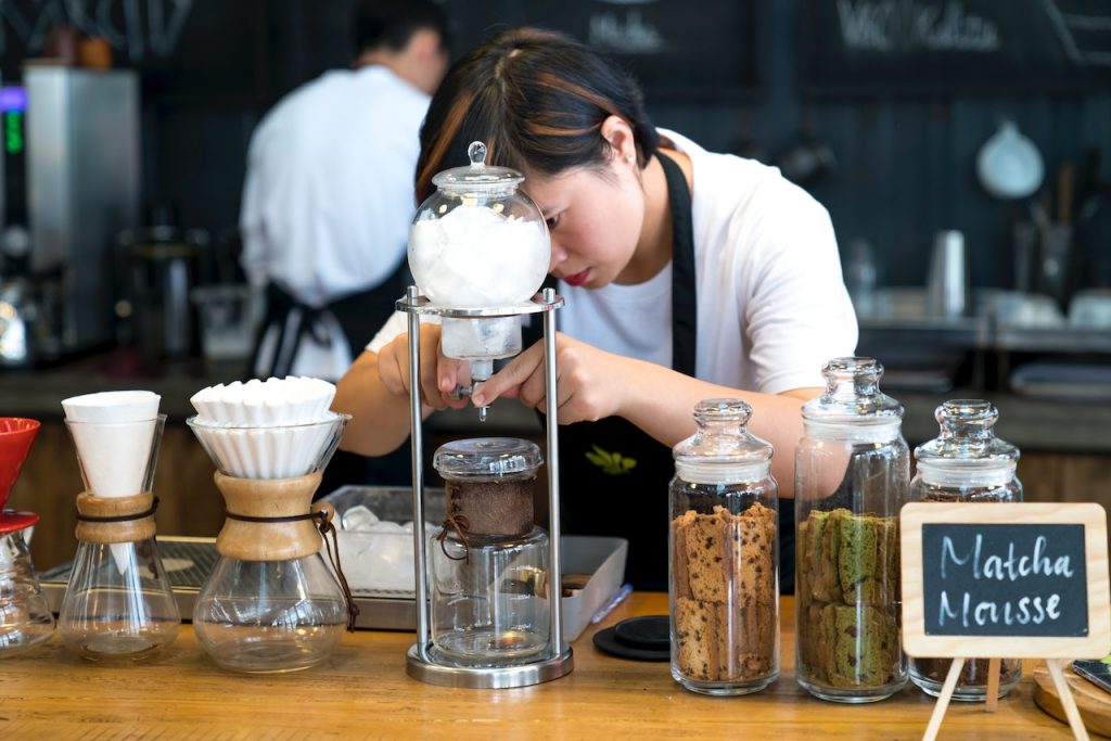 Ein kreativer Barista, der sein Fachwissen unter Beweis stellt, indem er mit verschiedenen Kaffeezubereitungsmethoden experimentiert und so seine Leidenschaft und Hingabe für sein Handwerk unter Beweis stellt.